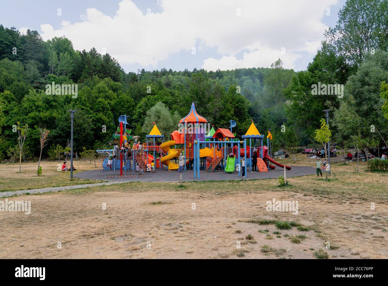 Ankara/Türkei-August 09 2020: Viele Kinder spielen auf einem bunten Kinderspielplatz mit Bäumen im Hintergrund Stockfoto
