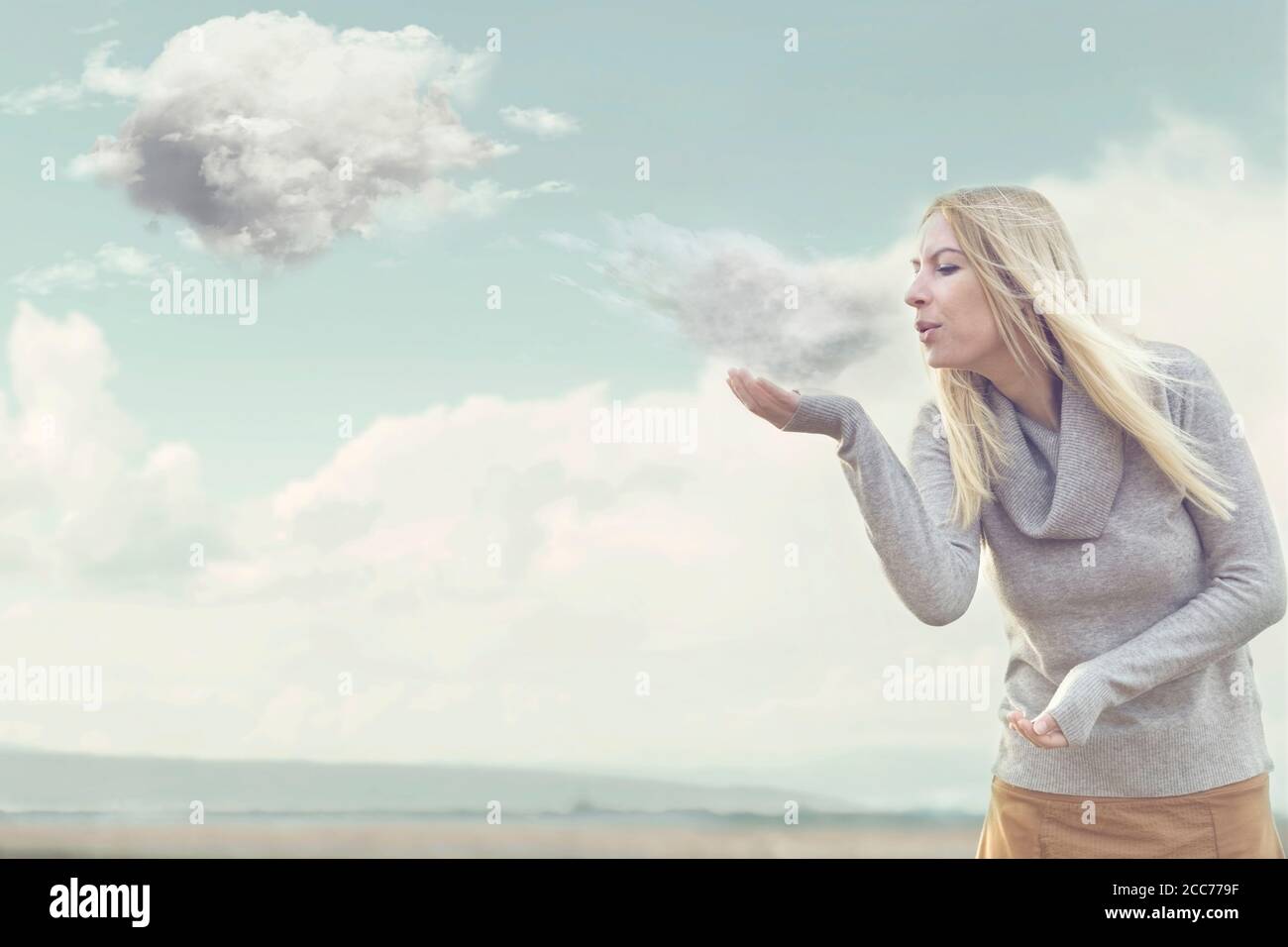 Frau mit magischen Kräften, die Wolken wehen lassen Stockfoto