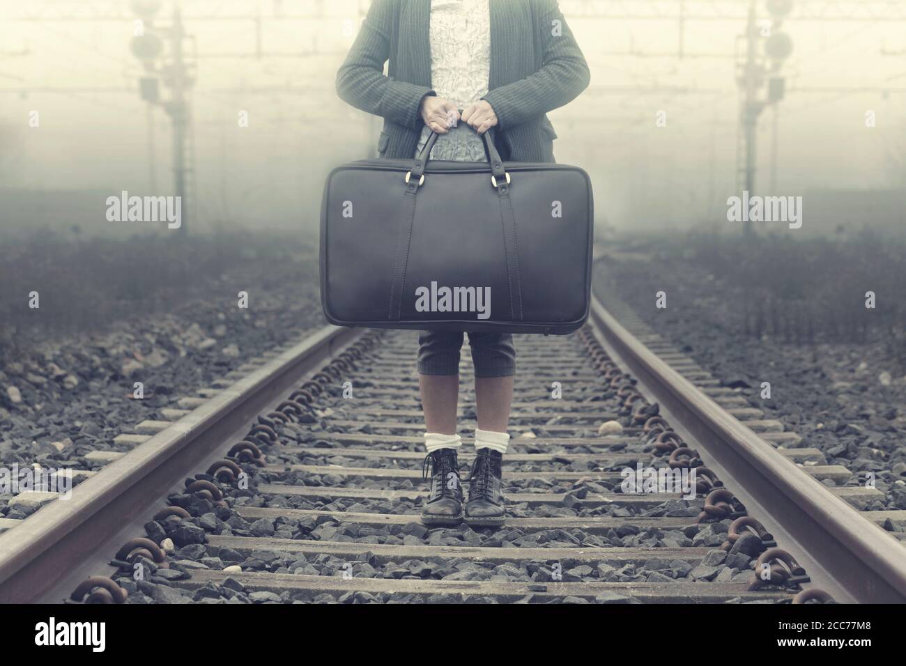 Gesichtslose Person erwartet am Bahnhof einen Zug zu Freiheit Stockfoto