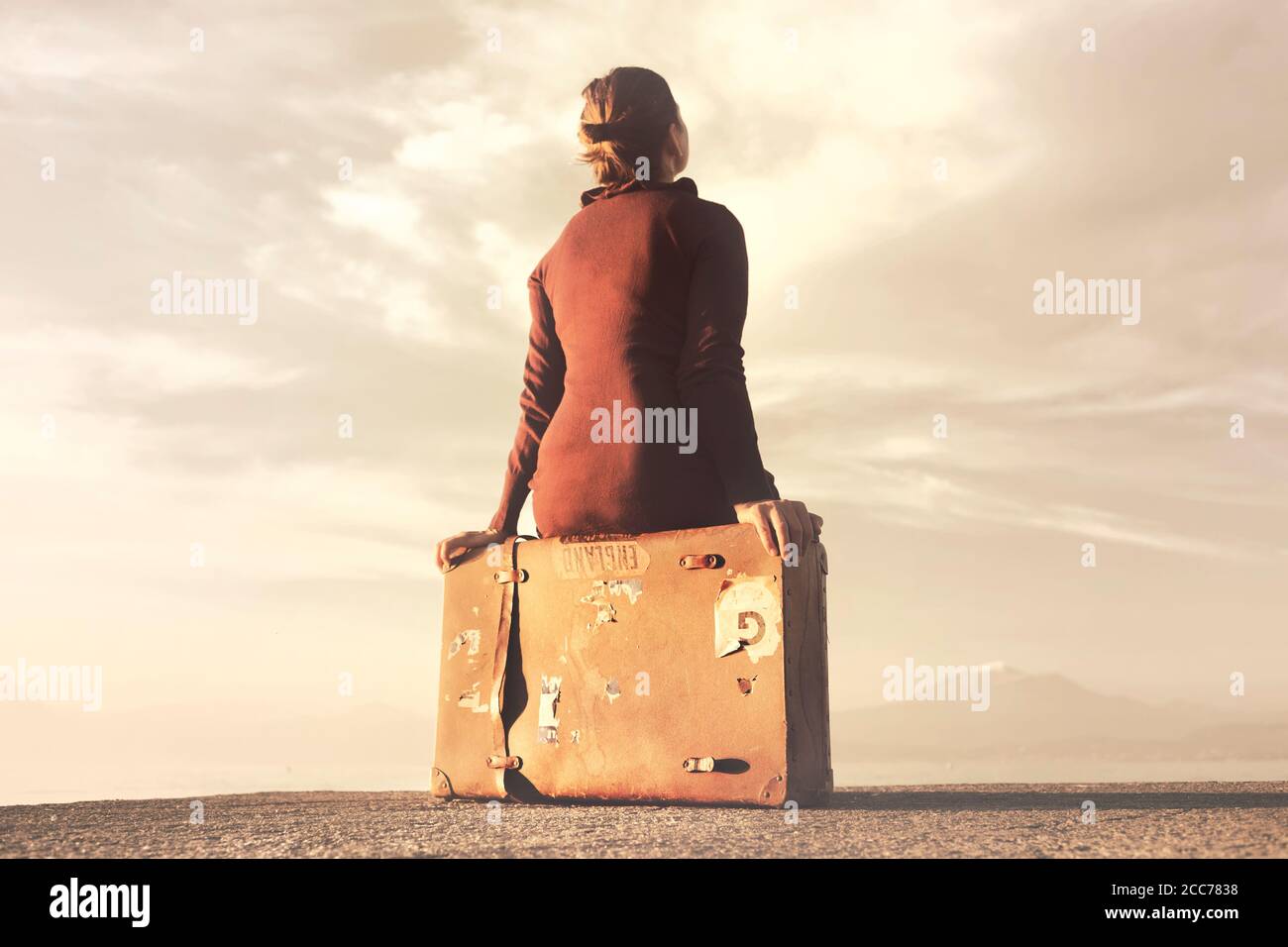 Reisende Frau Ankunft am Ziel entspannt sitzen auf ihrem Koffer Stockfoto