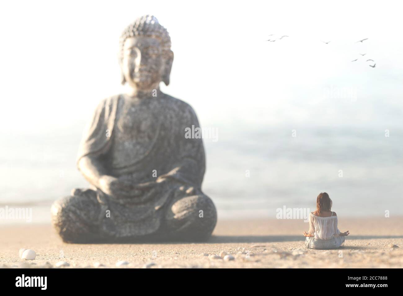 Frau meditiert vor der buddha-Statue im Mitten in der Natur Stockfoto