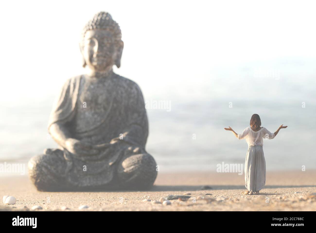 Frau macht Yoga-Übungen vor der Buddha-Statue Stockfoto
