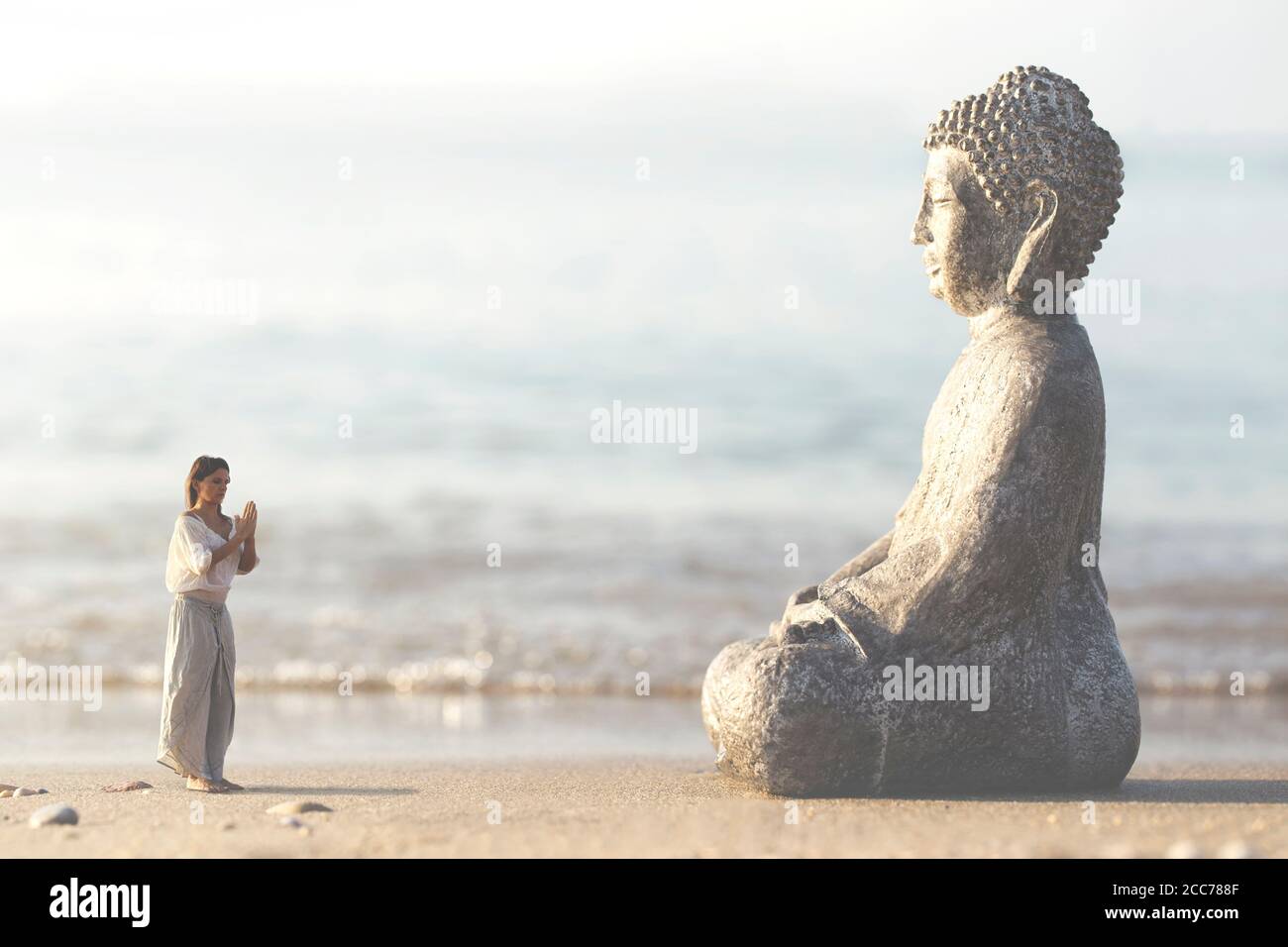 Frau betet vor der Buddha-Statue meditierend Stockfoto