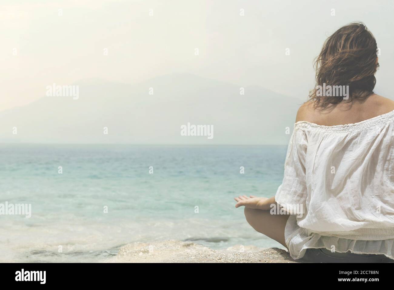 Frau macht Yoga-Übungen vor dem Ozean Stockfoto