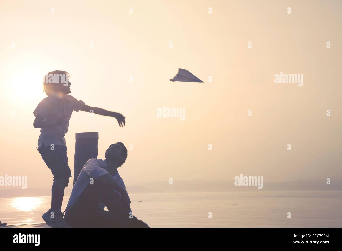 Glückliches Kind lässt sein Papierflugzeug fliegen Stockfoto