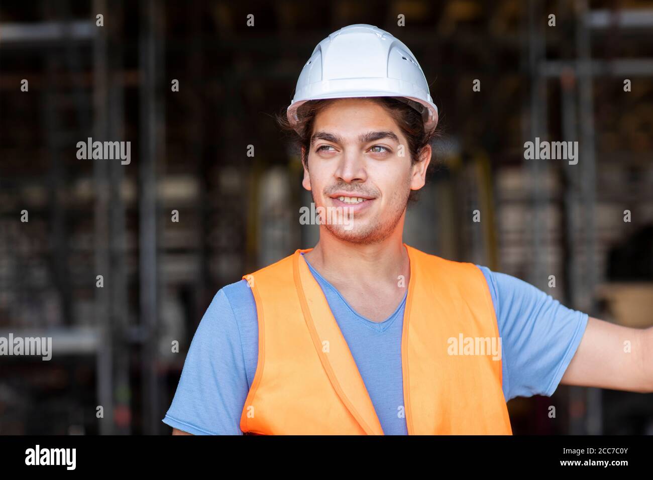 Junger Bauingenieur mit Helm, der draußen arbeitet Stockfoto