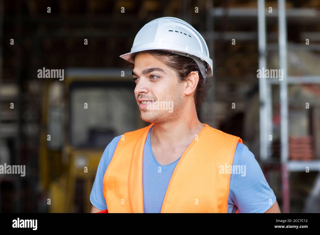 Junger Bauingenieur mit Helm, der draußen arbeitet Stockfoto