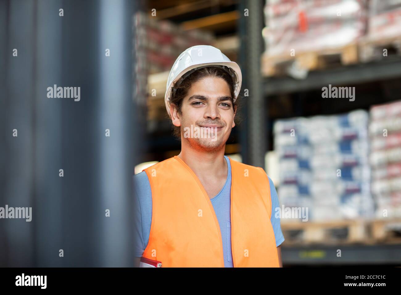Junger Ladenarbeiter mit Helm, der in einem Geschäft arbeitet Stockfoto
