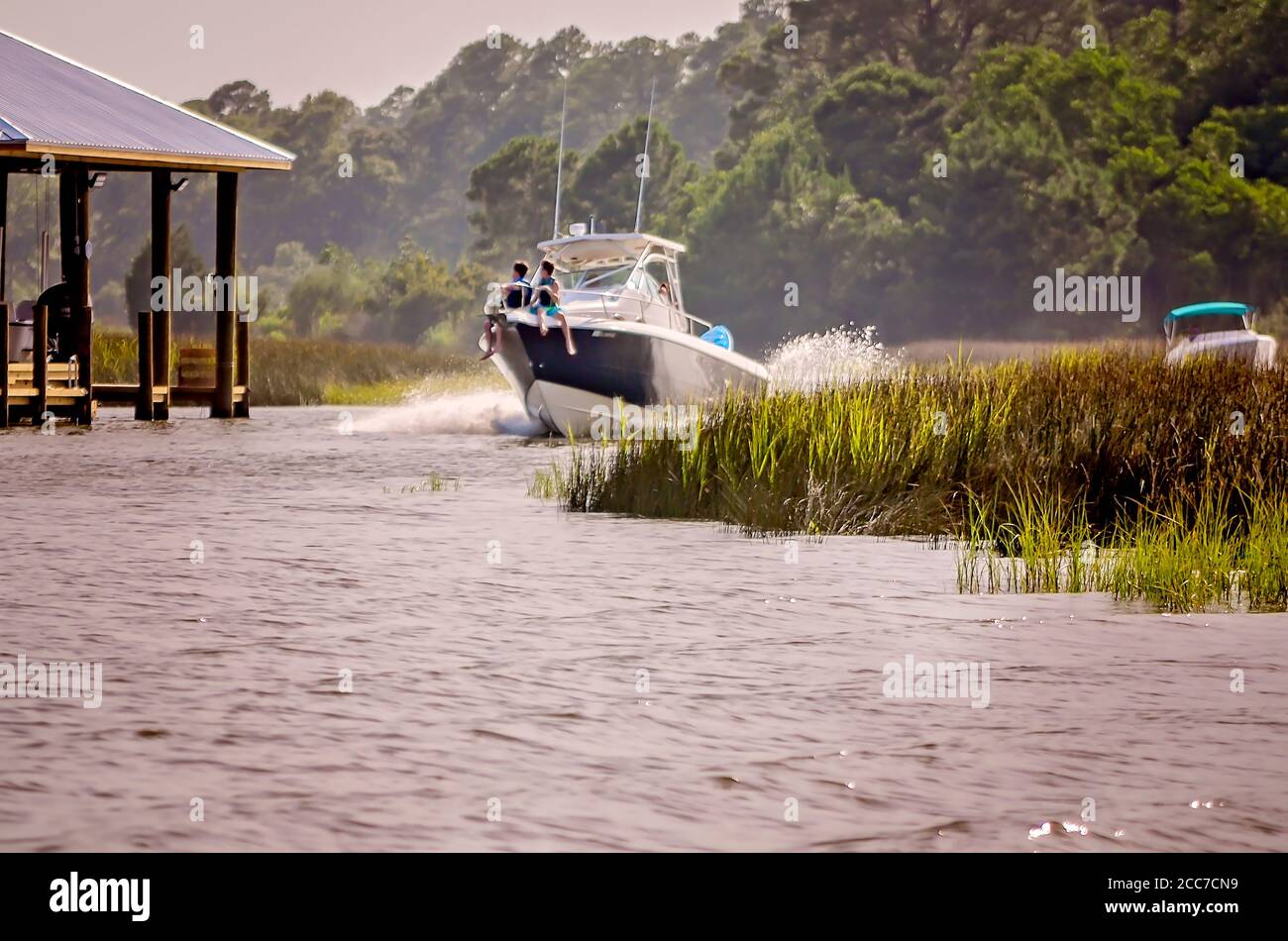 Kinder fahren auf dem Bug eines Vergnügungsbootes, während es am Fowl River entlang fährt, 6. Juli 2019, in CODEN, Alabama. Stockfoto