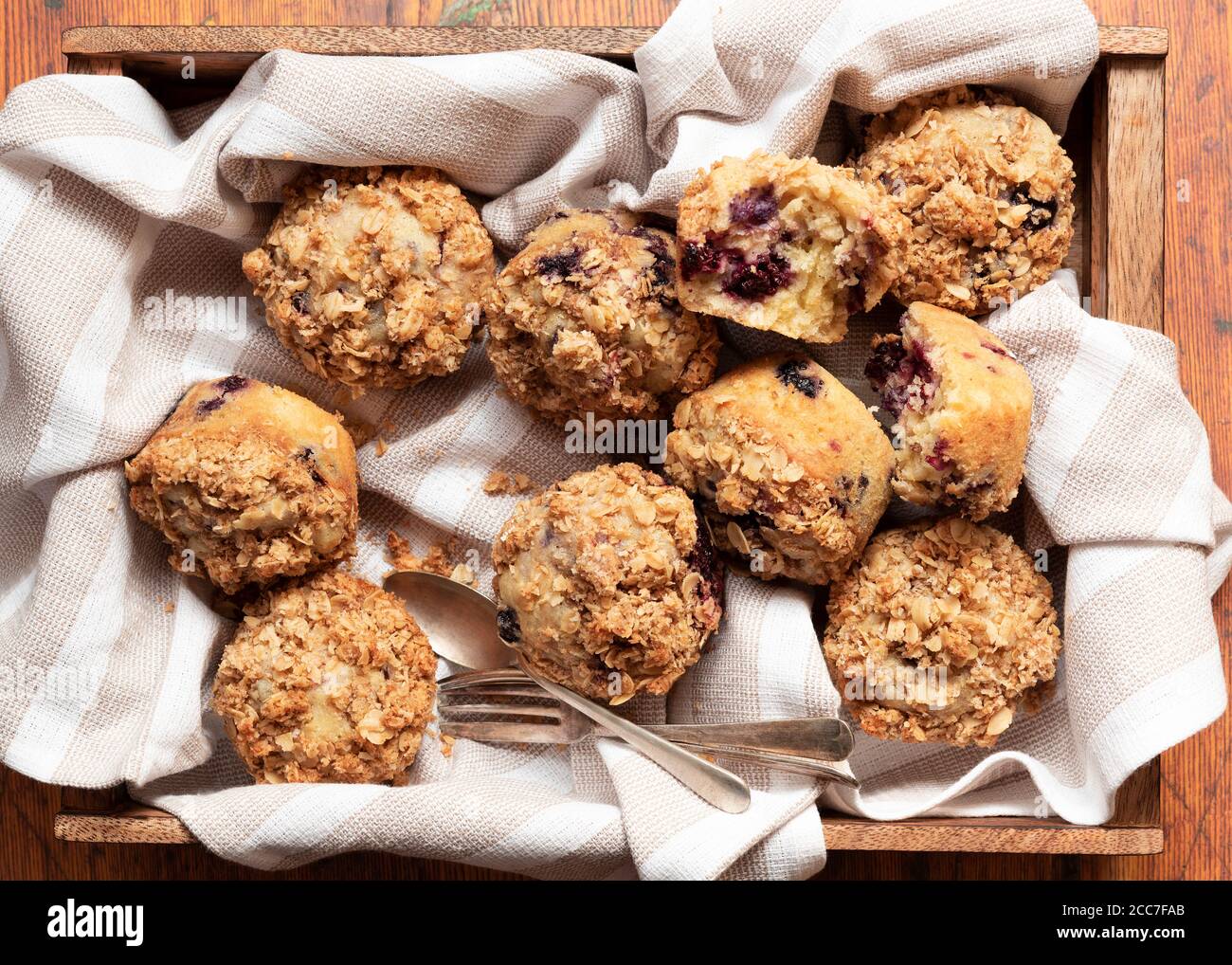 Gemischte Beeren- und Hafermuffins auf einem Holztablett Stockfoto