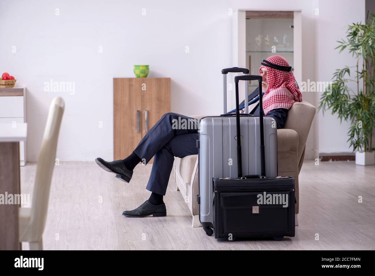 Der alte arabische Geschäftsmann bereitet sich auf die Geschäftsreise vor Stockfoto