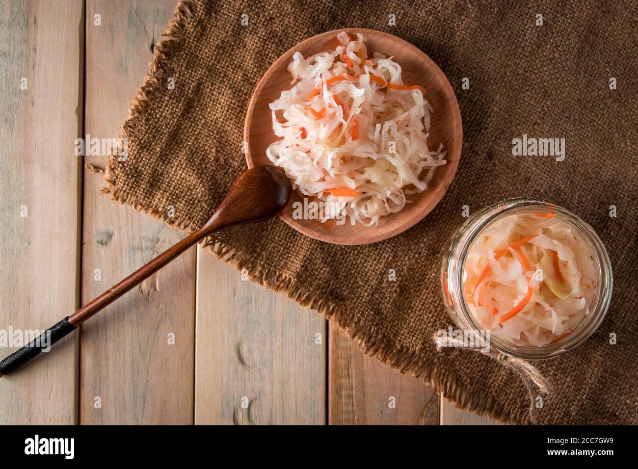 Hausgemachtes Sauerkraut auf Leinenhintergrund. Rustikaler Stil, Gemüsekonserven auf hellem Holzhintergrund. Öko-Lebensmittel, der Trend zu gesunder Ernährung. Stockfoto