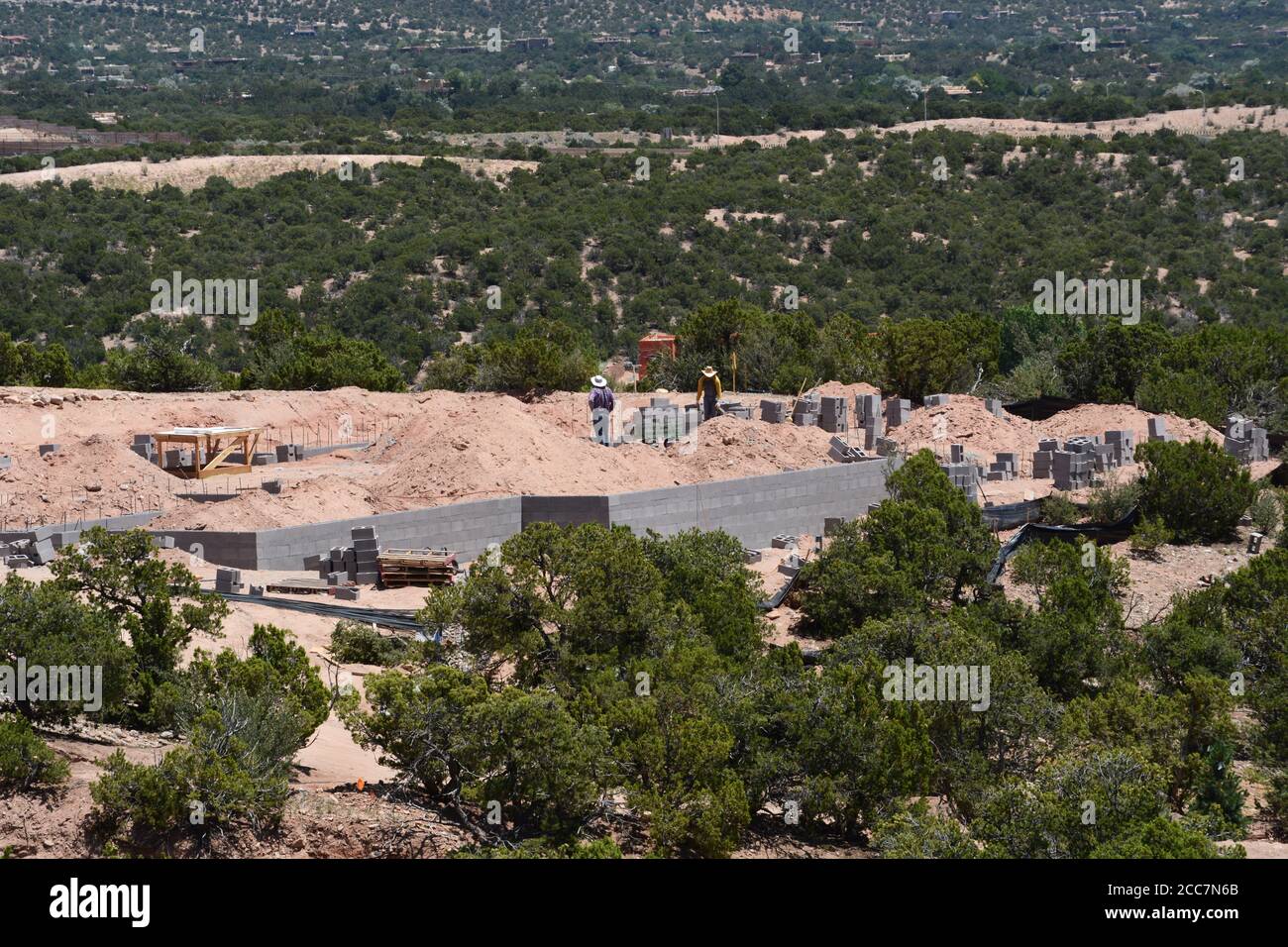Bauarbeiter legen eine Blockgründung für ein neues Haus, das mit Blick auf Santa Fe, New Mexico, USA gebaut wird. Stockfoto