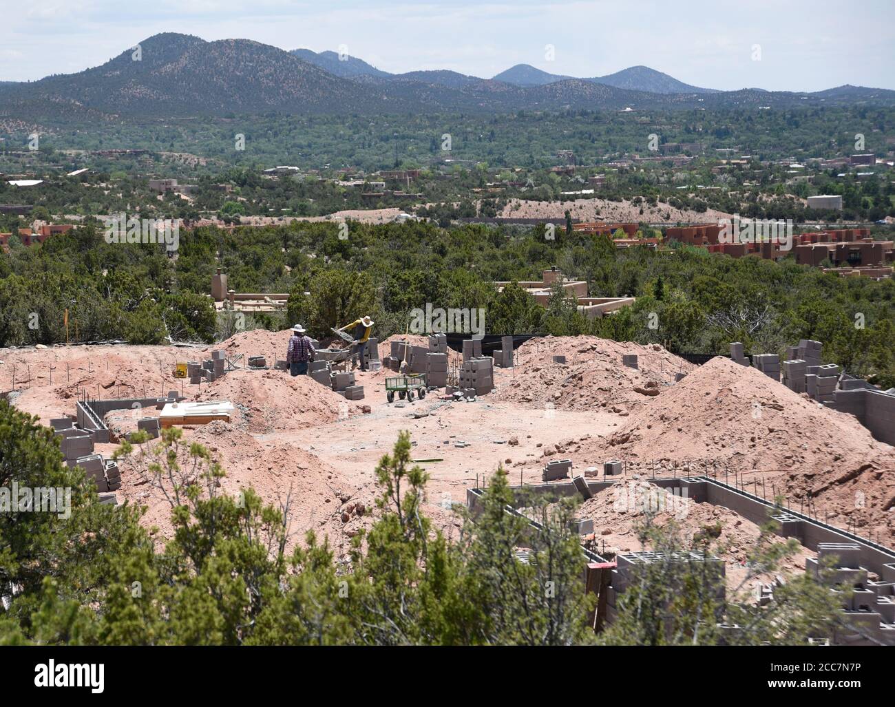 Bauarbeiter legen eine Blockgründung für ein neues Haus, das mit Blick auf Santa Fe, New Mexico, USA gebaut wird. Stockfoto