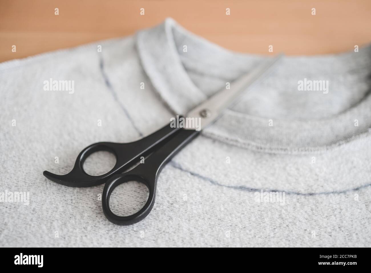 Mode diy und Upcycling alte Kleidung Konzept, Sweatshirt mit Schere, um  einen neuen Ausschnitt zu schneiden Stockfotografie - Alamy