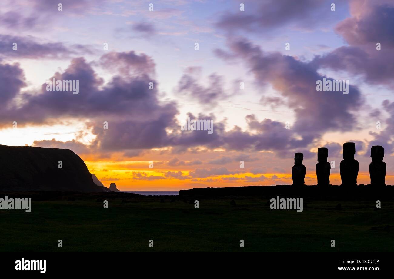 Silhouette von Moai Statuen bei Sonnenaufgang mit langer Belichtung und verwischen Bewegung von Wolken, Ahu Tongariki, Osterinsel, Chile. Stockfoto