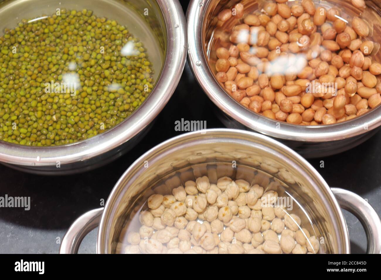 Frische grüne Gramm Bohnen und Erdnüsse mit channa auf schwarz Hintergrund Stockfoto