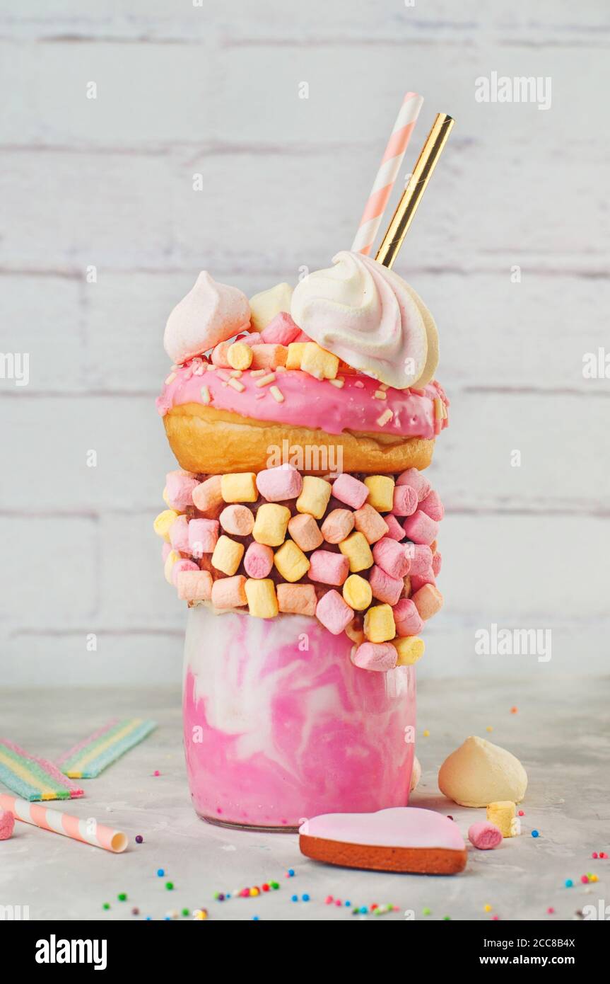 Raspberry Freak Shake Topping mit Donut auf grauem Hintergrund Stockfoto