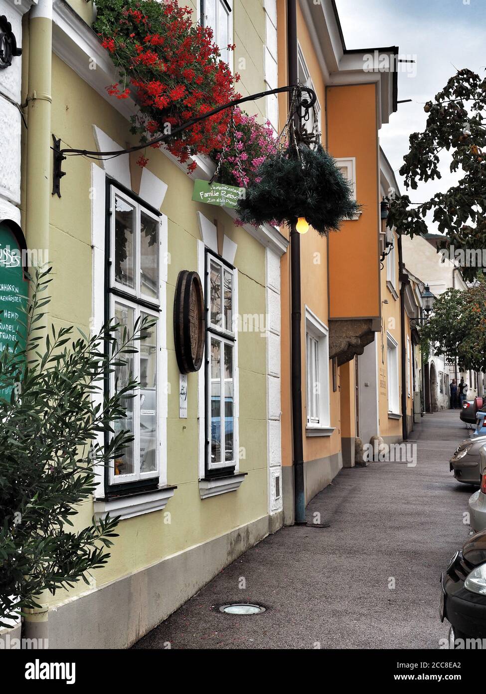 GUMPOLDSKIRCHEN, ÖSTERREICH - 09/01/2018. Blick auf den leeren Gang und die Fassade der Häuser mit Blumen in den Fenstern. Stockfoto