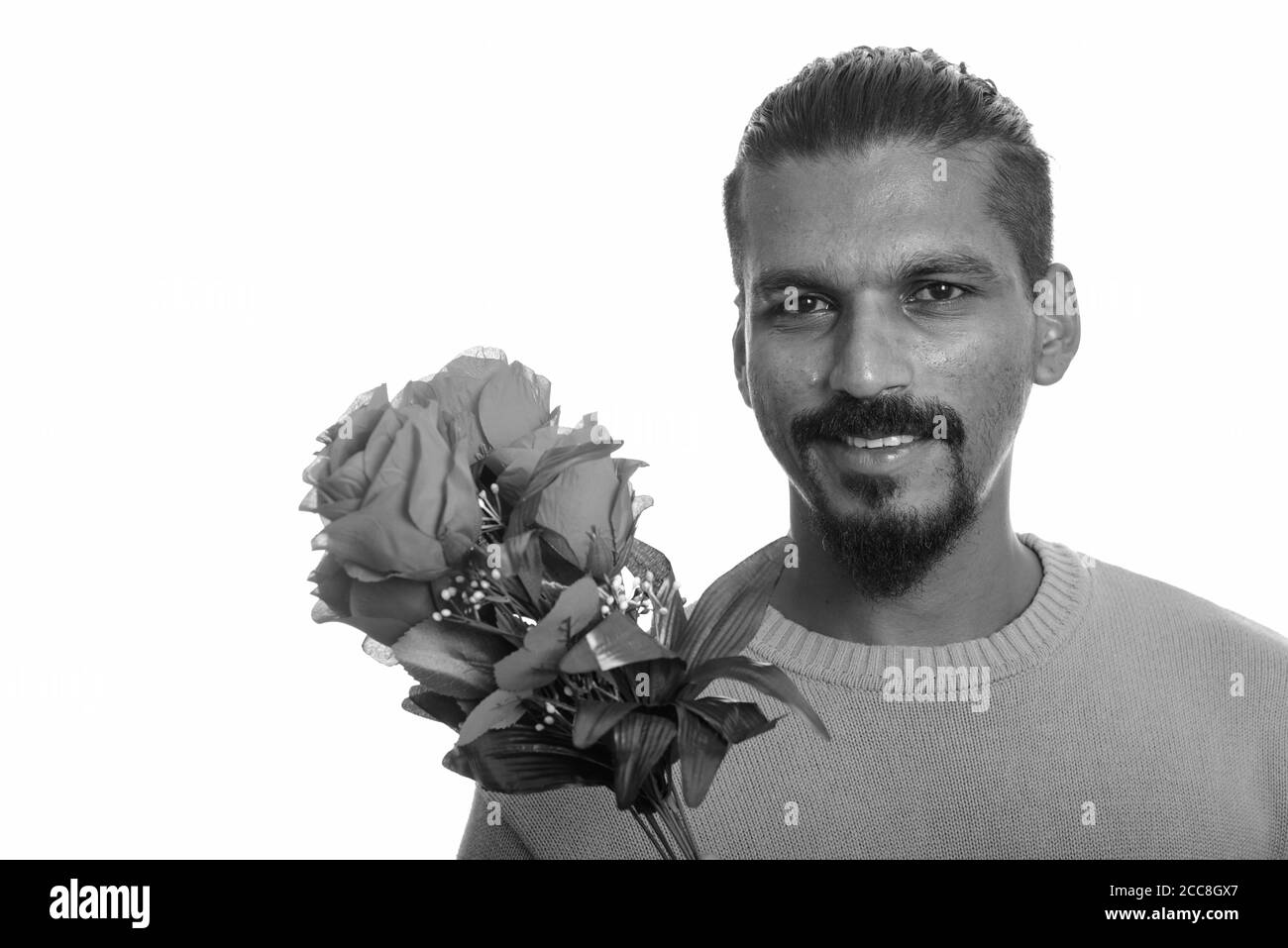 Junge glücklich indischen Mann mit roten Rosen zum Valentinstag bereit Stockfoto