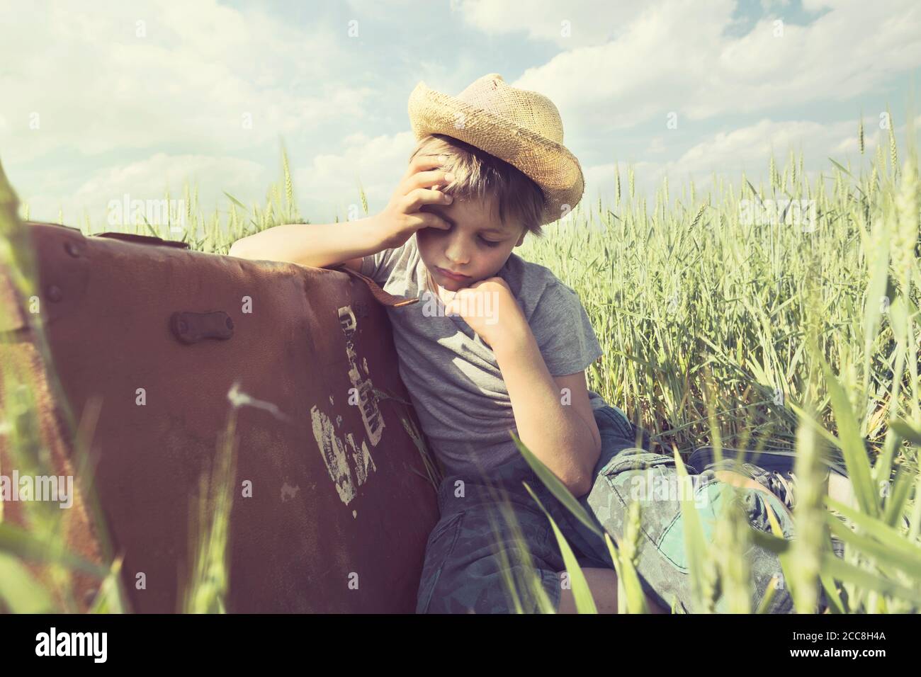 Müde Cowboy schläft nach einer langen Reise auf seinem Koffer Stockfoto