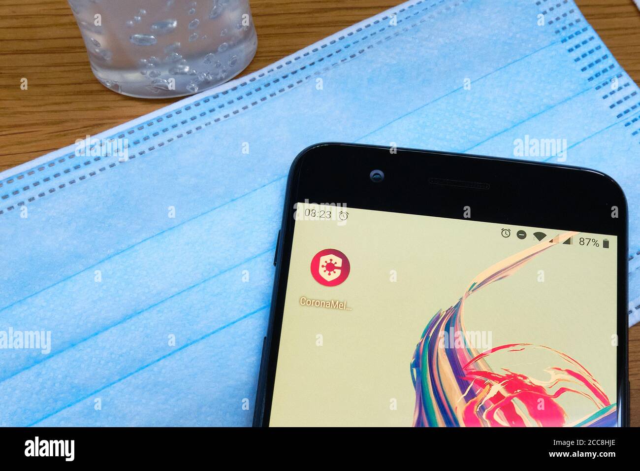 Bennekom,Niederlande,Aug,20,2020:Smartphone mit Symbol der niederländischen Corona Tracking App namens:Coronamelder. Gesichtsmaske, Desinfektionsmittel.die Regierung will Stockfoto