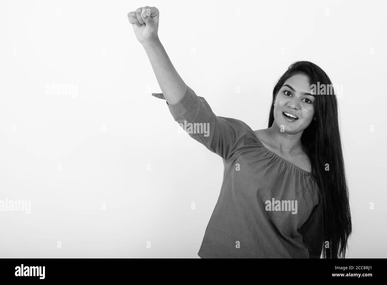 Studio shot der jungen indischen Glücklich lächelnde Frau, während sie gegen den weißen Hintergrund motiviert Stockfoto