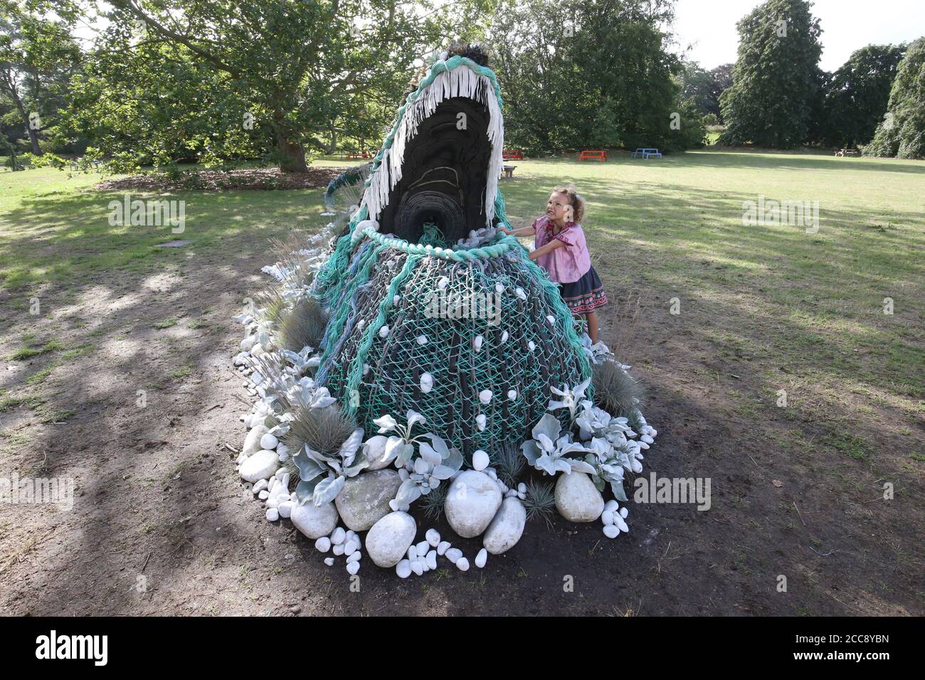 Die fünfjährige Sylvie Fodio Todd aus Lewes blickt auf die botanische Skulptur eines Buckelwals, der aus dem Orangery Lawn auftaucht, während er bis September 18 im Rahmen des Travel the World at Kew Festivals in den Royal Botanic Gardens in London zu sehen ist. Stockfoto