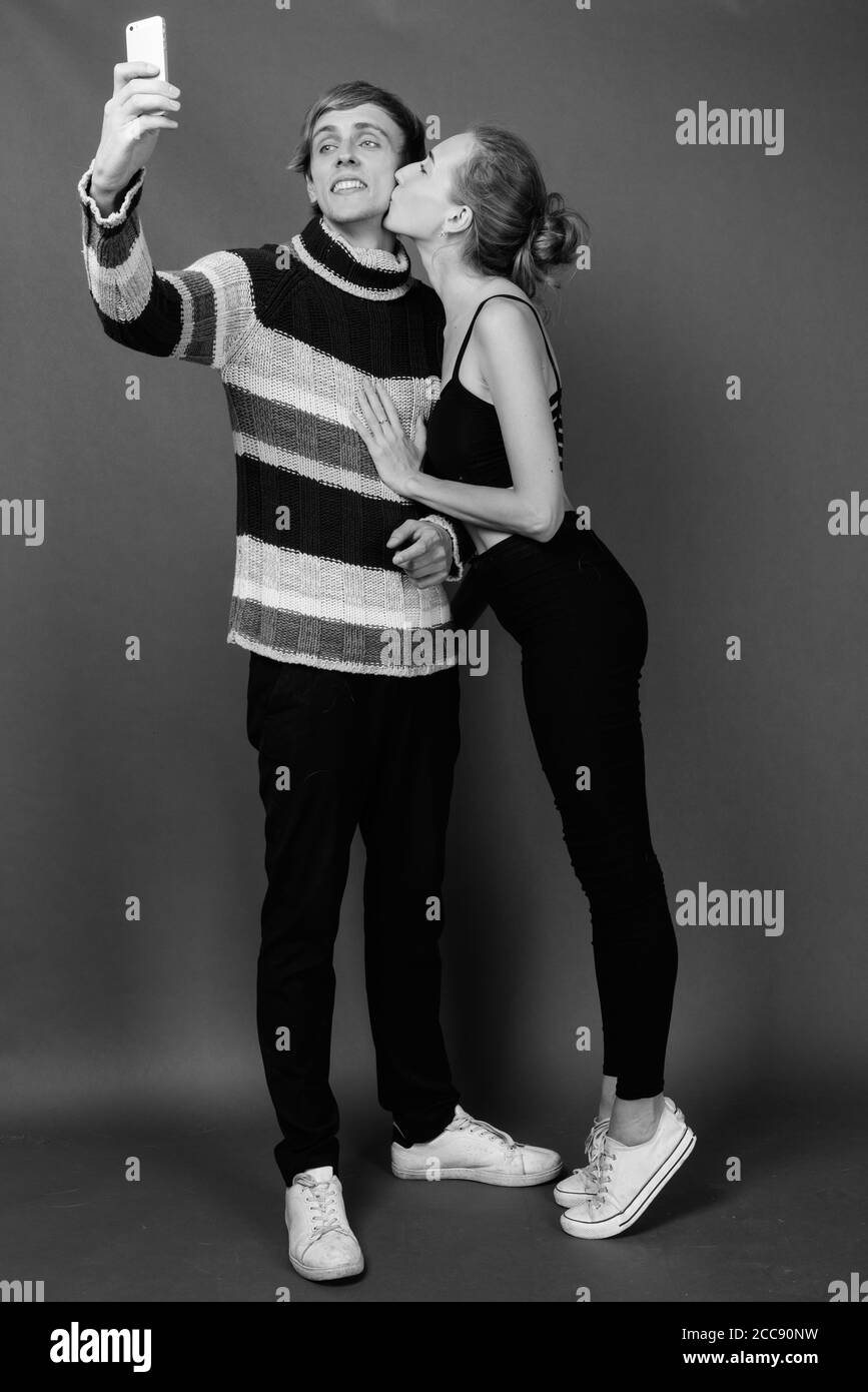 Studio Aufnahme des jungen Paares gemeinsam gegen grauer Hintergrund Stockfoto