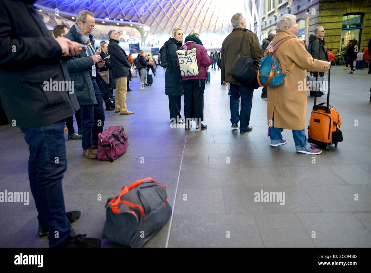 London, England, Großbritannien. Passagiere, die auf der Bahnhofsstation Kings Cross warten Stockfoto