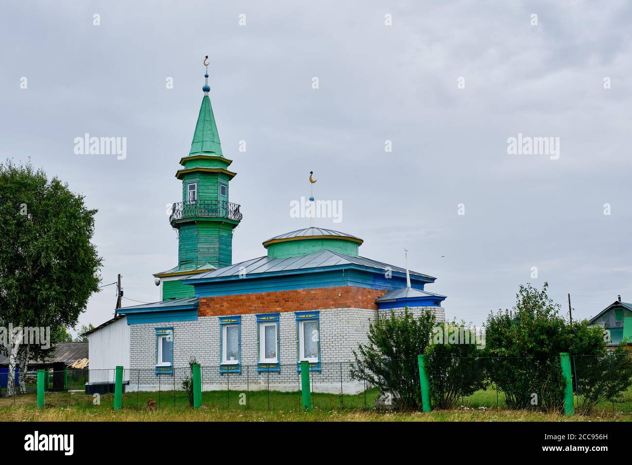 Tjumen, Russland - 16. August 2020: Moschee aus weißen Ziegeln mit einem grünen Minarett aus Holz im sibirischen Dorf Sabanaki an einem bösen Tag Stockfoto