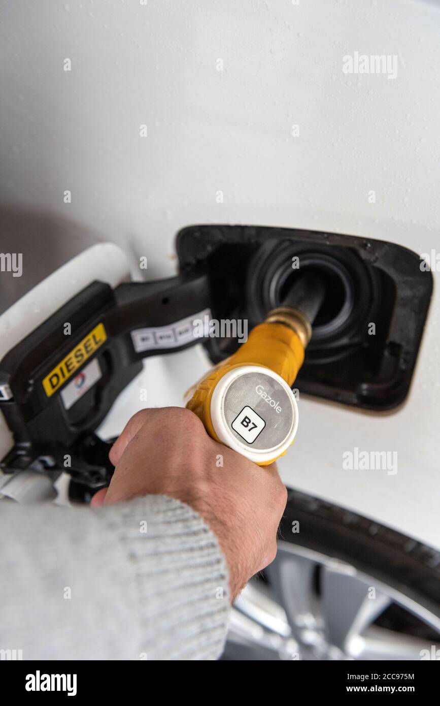 Nahaufnahme der Hand eines Mannes, der den Tank seines Autos mit Diesel füllt. Diesel B7 gelbe Düse Stockfoto