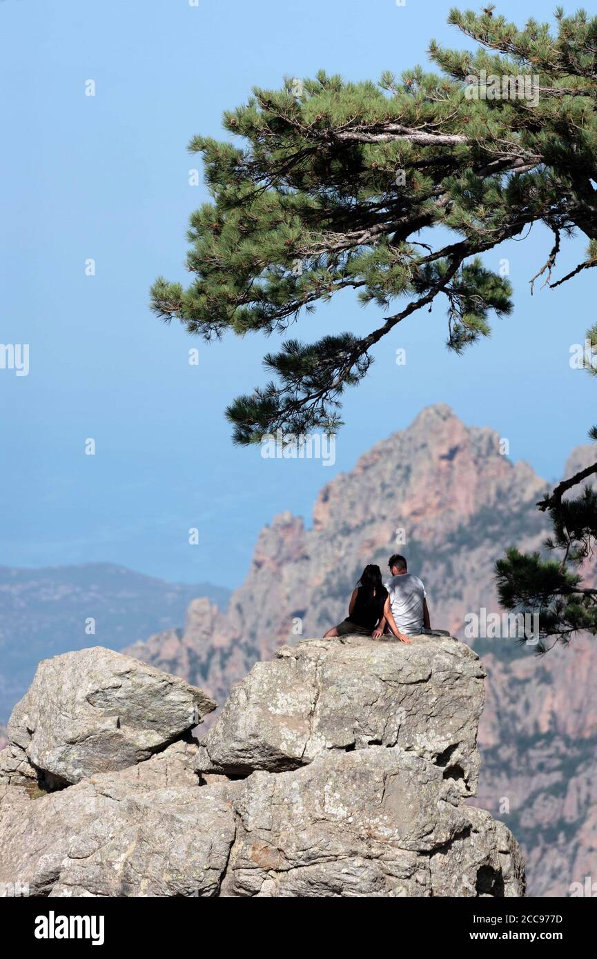 Südkorsika: Paar sitzt und umarmt vor der herrlichen felsigen Landschaft der Bavella Berge. Stockfoto