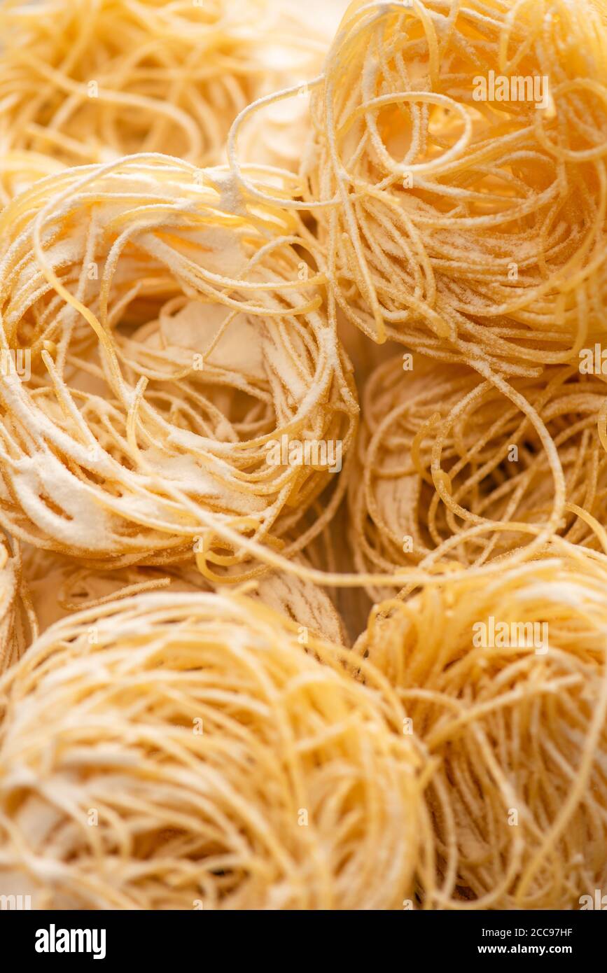 Nahaufnahme von rohen italienischen Capellini mit Mehl Stockfoto