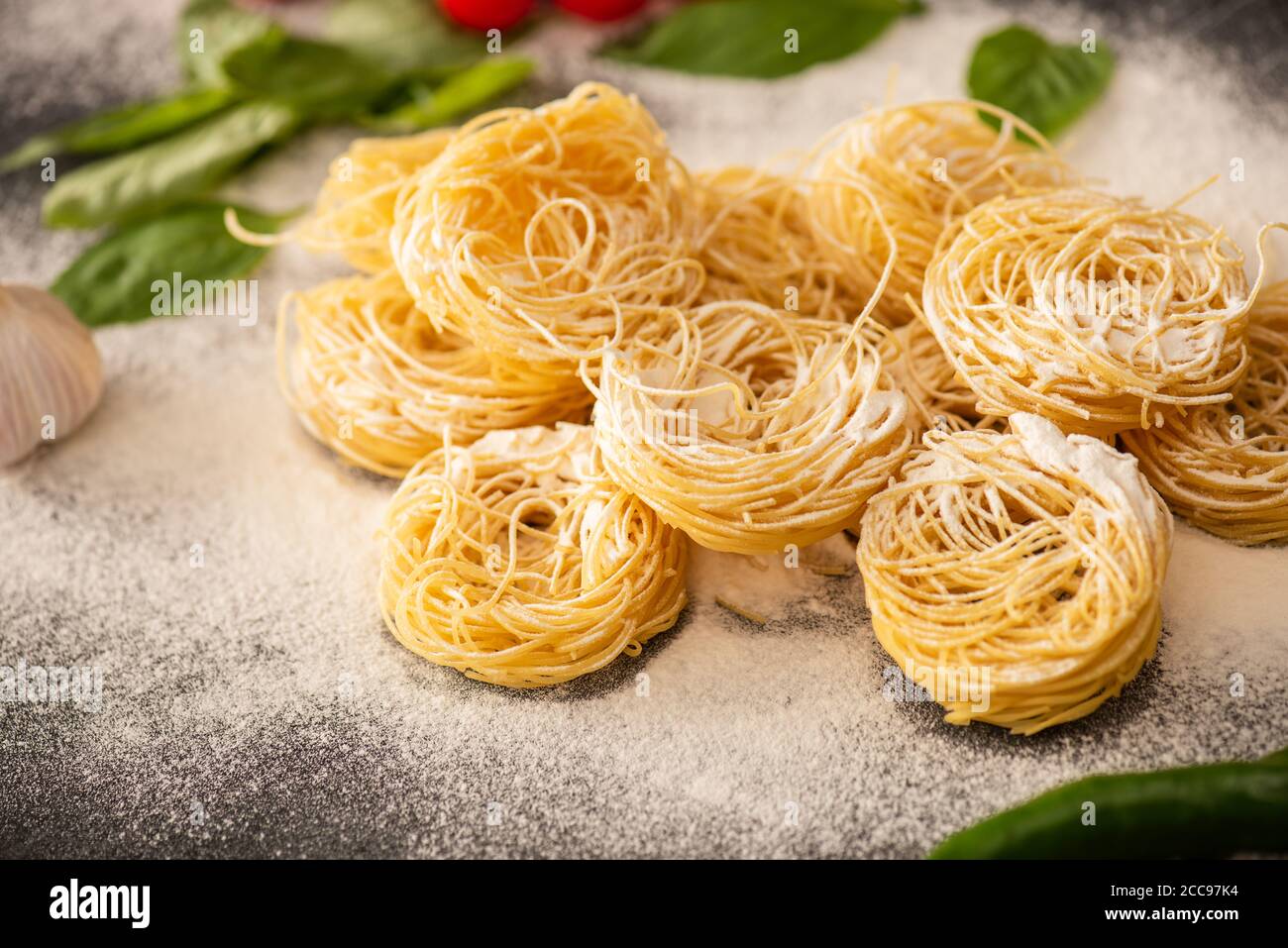 Rohe italienische Capellini mit Mehl und schwarzem Pfeffer Stockfoto