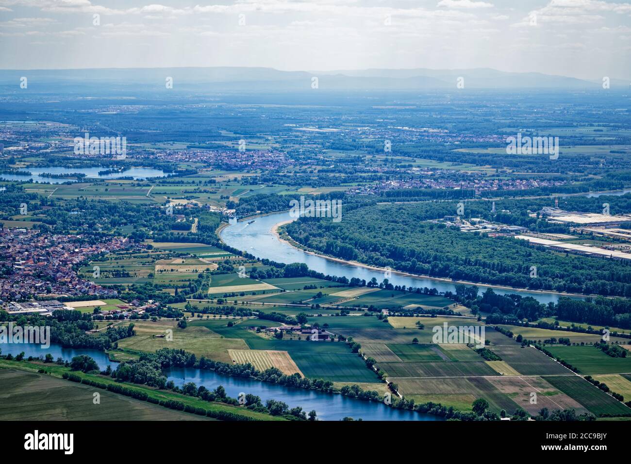 Der Rhein schlängelt sich durch das Tal seines Namens. In der Ferne liegt der Schwarzwald, in den Vordergrund Felder und Auen. Stockfoto