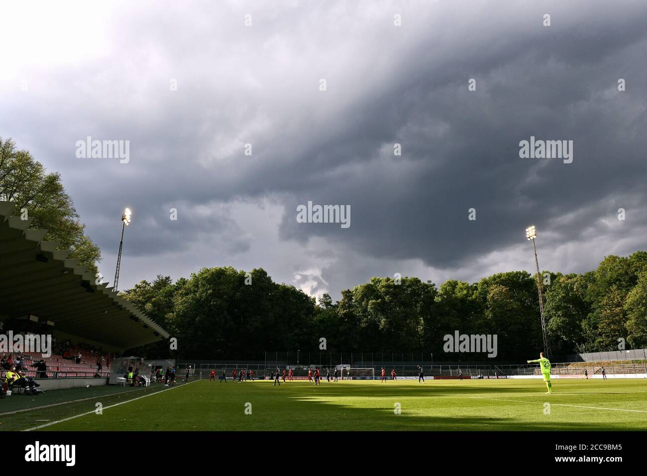 Fußballspiel im Franz Kremer Stadion unter einem dramatischen Himmel. Stockfoto