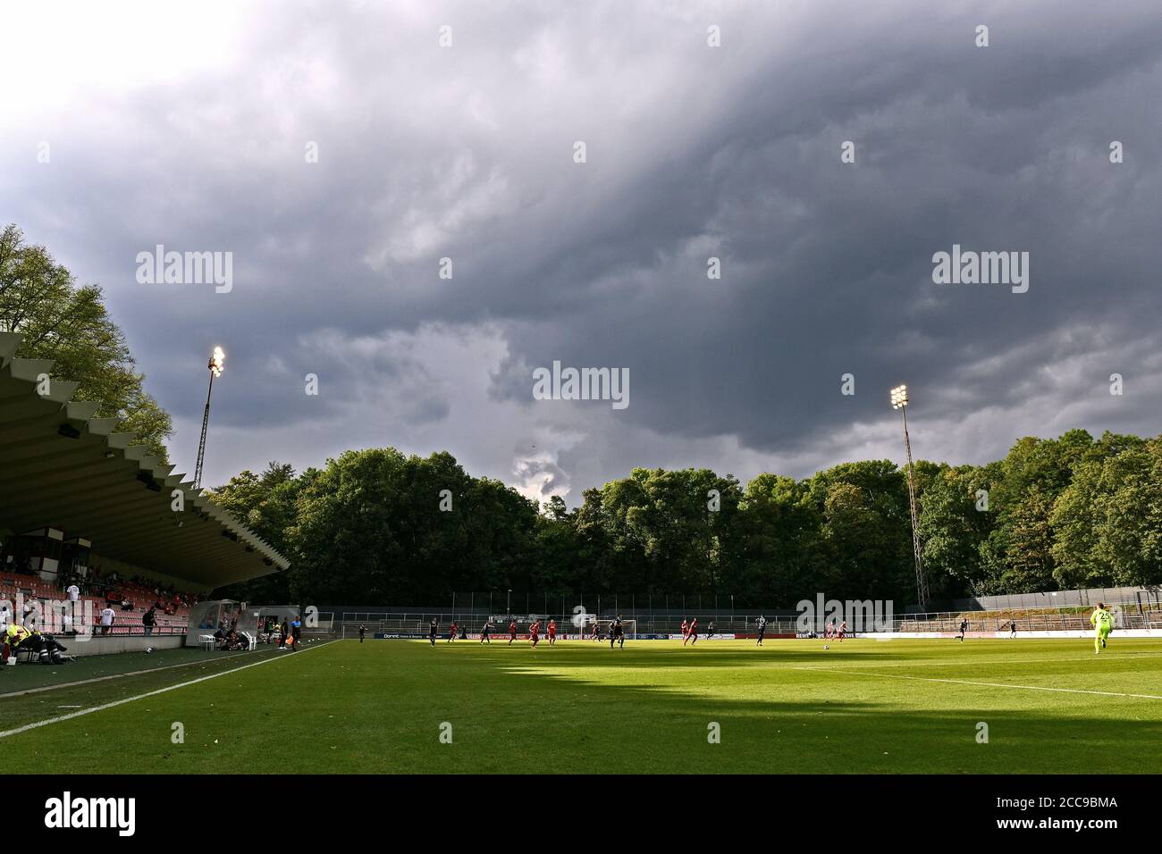 Fußballspiel im Franz Kremer Stadion unter einem dramatischen Himmel. Stockfoto