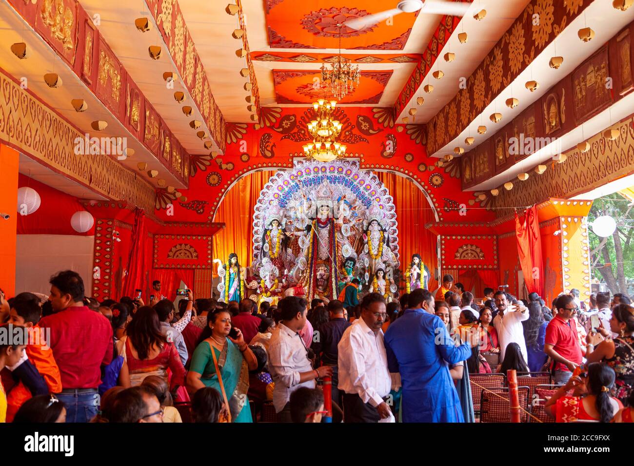 Ansicht einer Statue der Göttin Durga, während eifrige Anhänger sich versammeln Ihre Gebete darbringen Stockfoto
