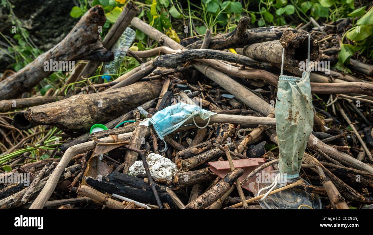 Müll aus gebrauchten medizinischen Masken und Handschuhen am Strand. Schlechte Folgen wie Verschmutzung oder Verschmutzung der Natur und der Wassermeere. Umgebunga Stockfoto