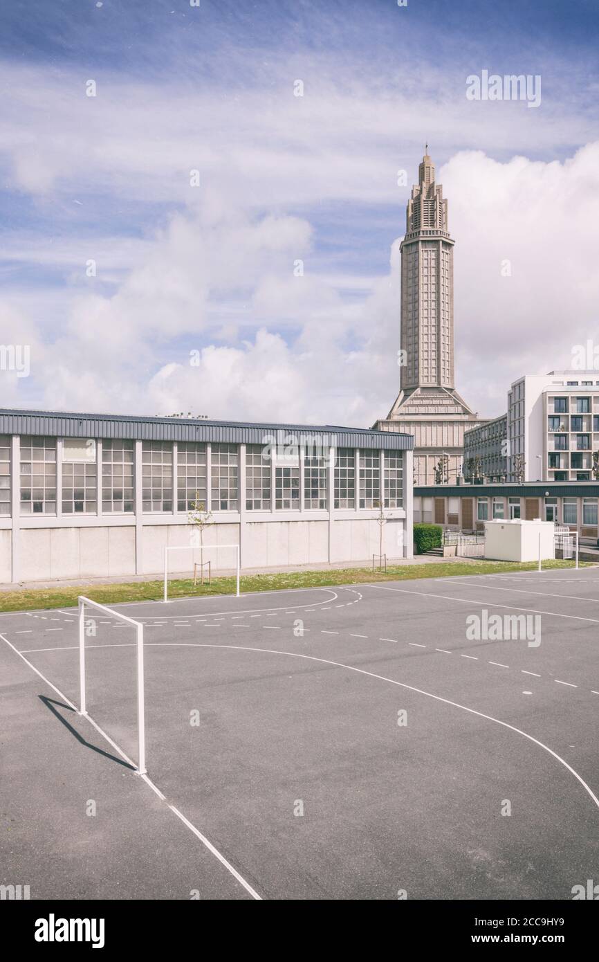 Gebäude aus der Mitte des Jahrhunderts in Le Havre, Frankreich, Schulhof und Fitnessraum im Vordergrund, Wohngebäude und Glockenturm der Kirche Saint Josephs im Hintergrund. P Stockfoto