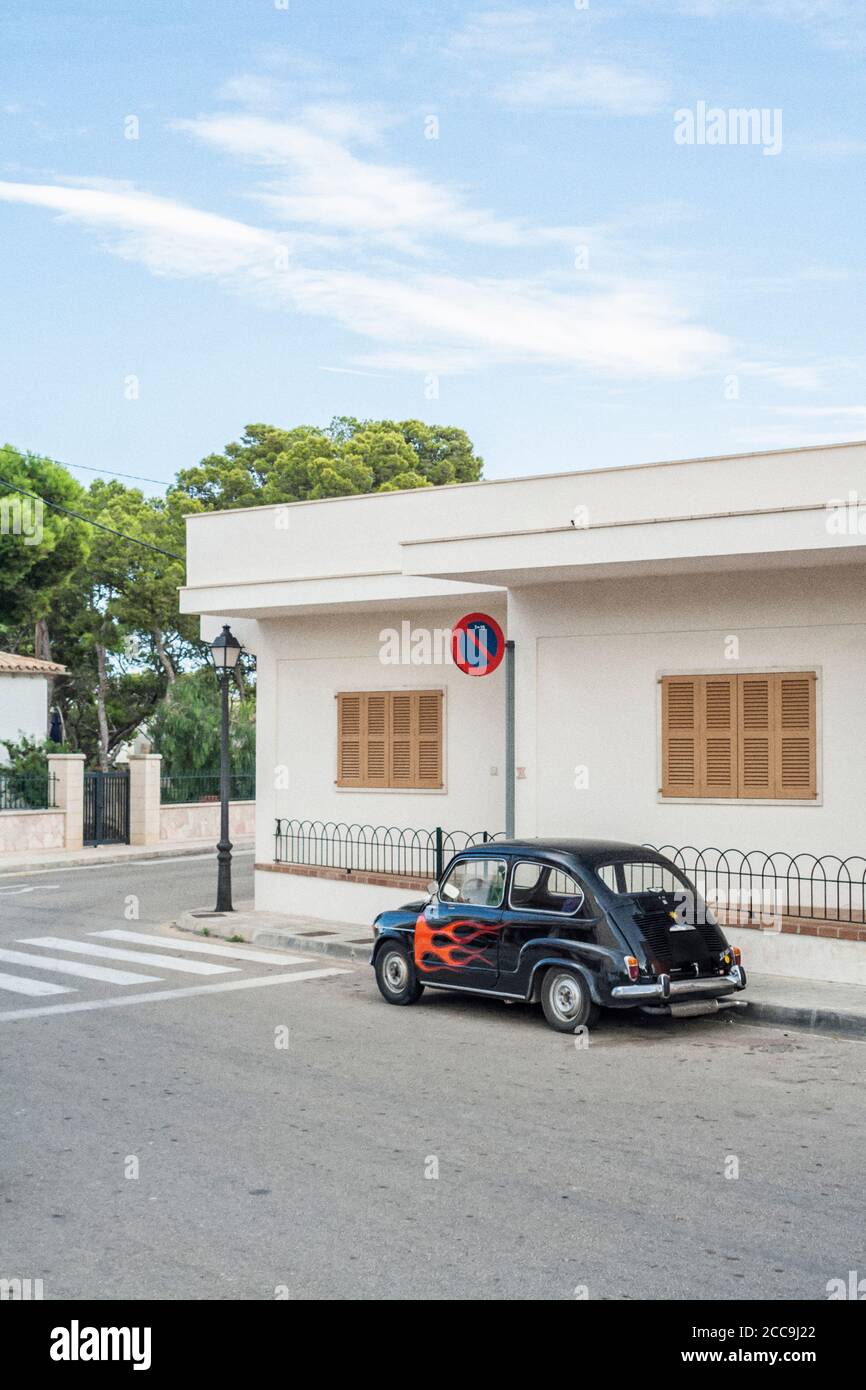 Vintage SEAT 600 Kompaktwagen mit Flammen-Design vor dem Bungalow auf Mallorca. Filmkörnung bei der Nachbearbeitung hinzugefügt. Stockfoto