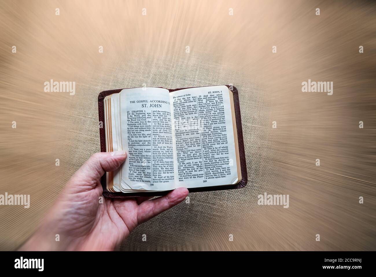 Eine gut benutzte rote Gideon's Bibel auf einem neutralen Hintergrund öffnete sich am Johannesevangelium. Das Buch enthält das Neue Testament und die Psalmen plus das Co Stockfoto