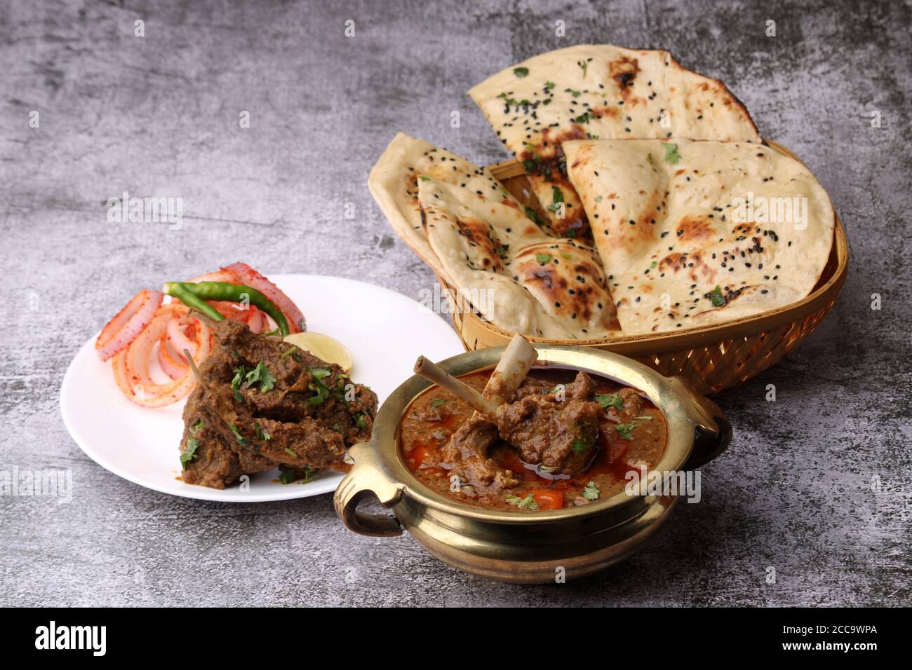 Hammelcurry serviert mit Naan oder Brot und Jeera-Reis auf Holzhintergrund. Stockfoto