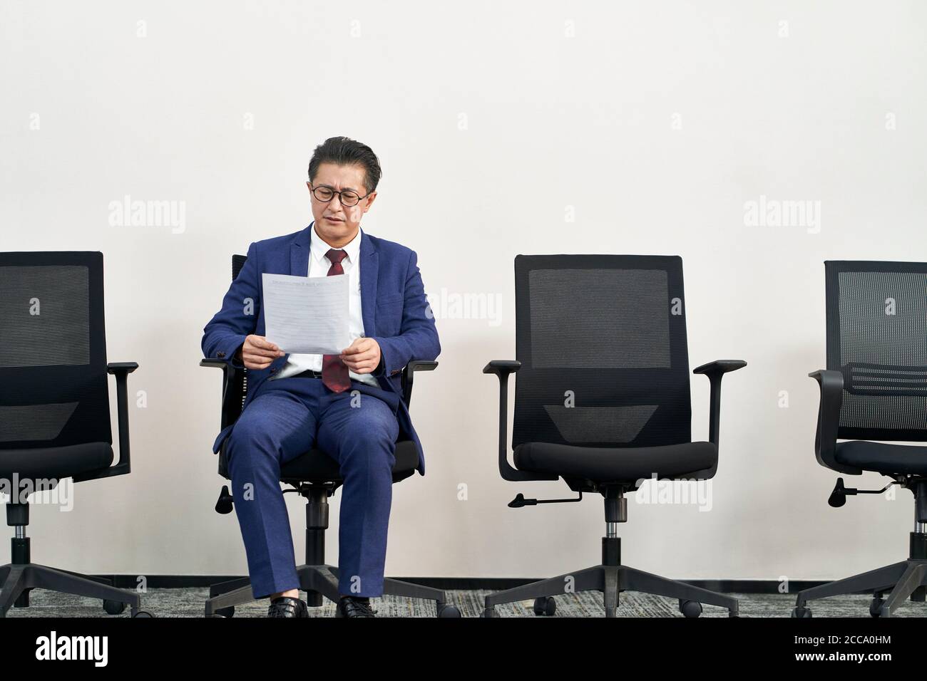 Reifen asiatische männliche Job Sucher Vorbereitung für Interview während warten In Reihe Stockfoto