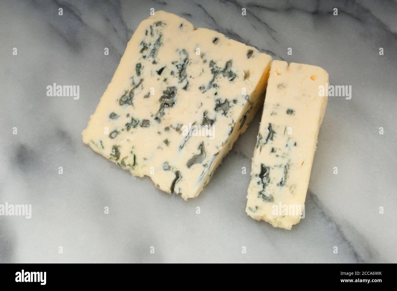 Studioaufnahme einer Scheibe Blauschimmelkäse, auf dem sich die Kamera aufraht Eine Marmorplatte - John Gollop Stockfoto