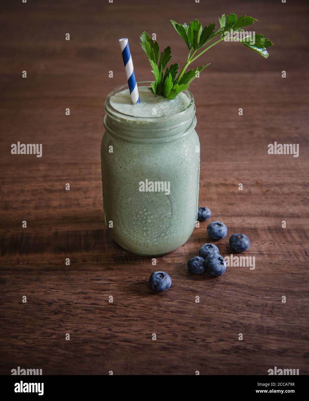 Grüner Smoothie mit Heidelbeeren und Grünpflanzen Stockfoto