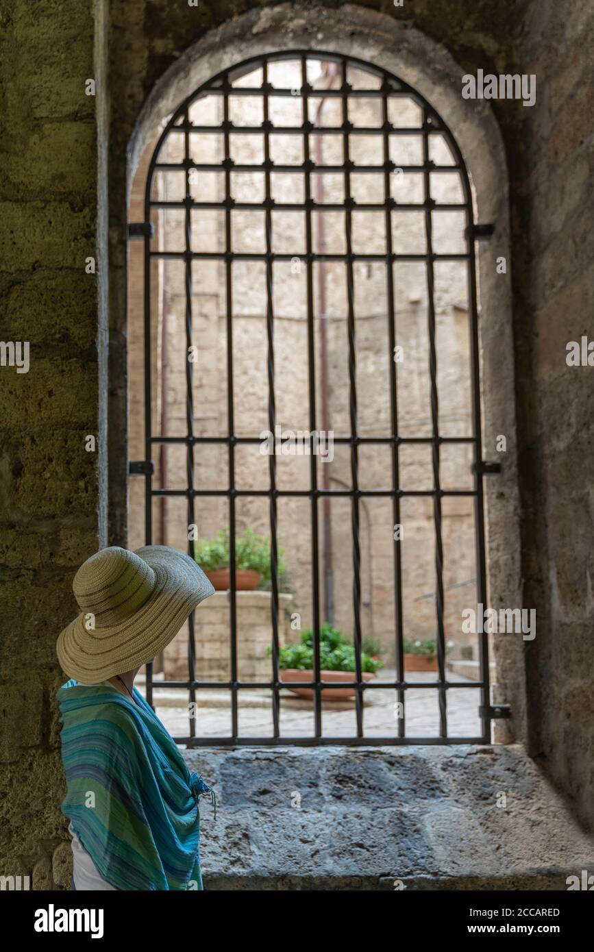 Ein Tourist schaut aus einem der Fenster von Der Bischofspalast in Rieti Stockfoto