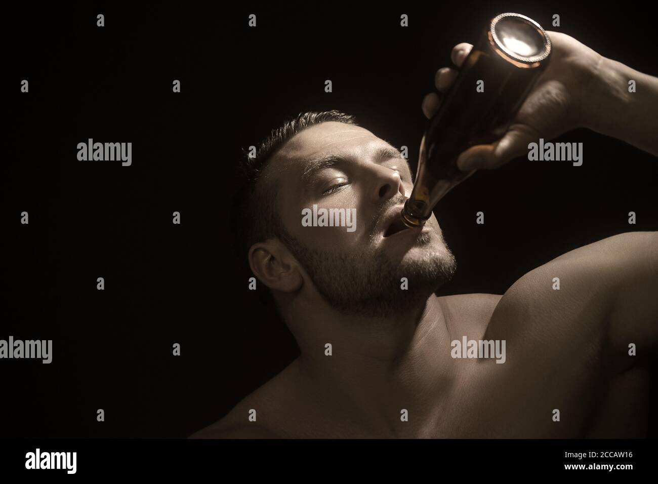 Stilvolle muskulösen Kerl genießt den Geschmack von Craft Bier. Studio Foto vor einem dunklen Hintergrund. Stockfoto