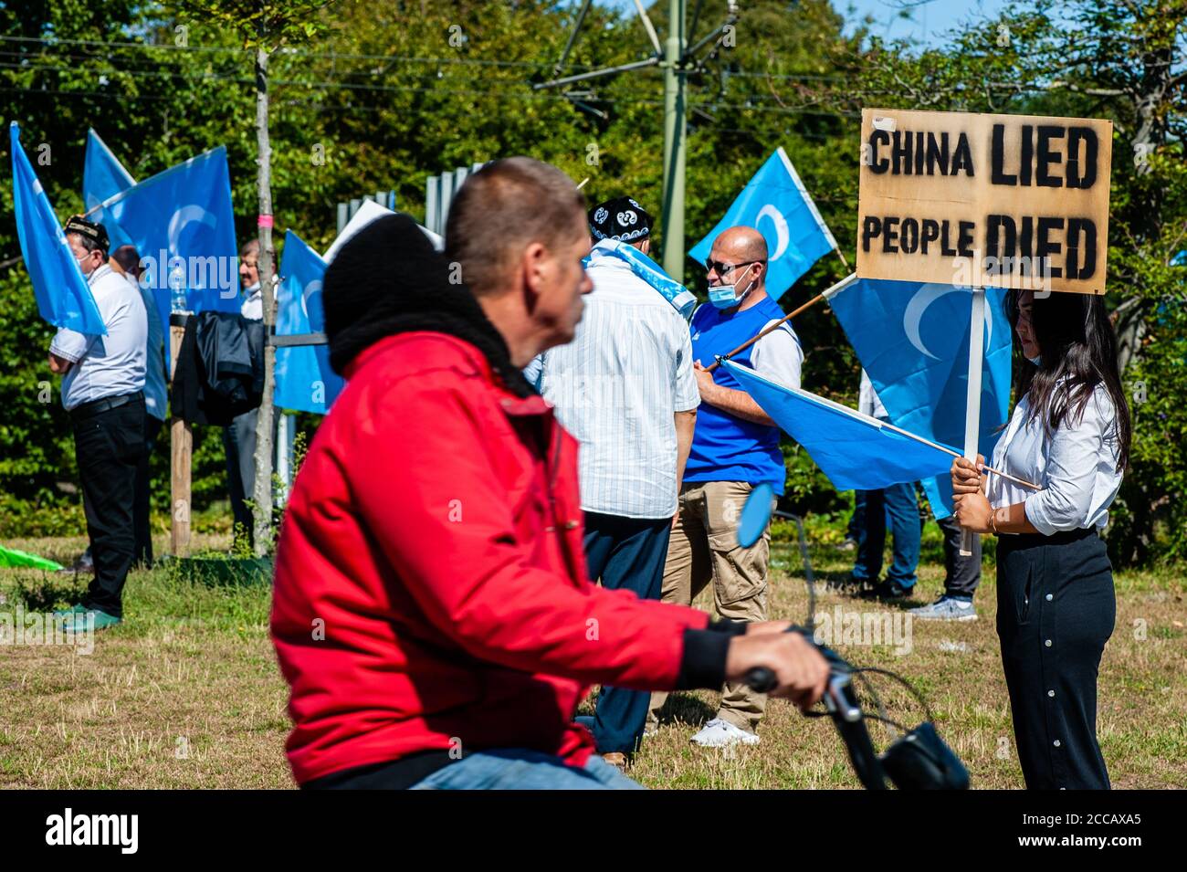 Eine Frau, die während der Demonstration ein Plakat gegen China hält.Extinction Rebellion Fashion Action NL (XRFA) hat sich mit der Ostturkestan Organization Alliance zusammengetan, um die öffentliche Aufmerksamkeit auf die Diskriminierung der Uiguren in China zu lenken. Demonstranten begannen am Koekamp, zur chinesischen Botschaft zu gehen, um eine offizielle Erklärung abzugeben, und Druck auf die niederländische Regierung und die chinesische Botschaft auszuüben, jetzt zu handeln und diese ethnische Säuberung zu stoppen. Stockfoto